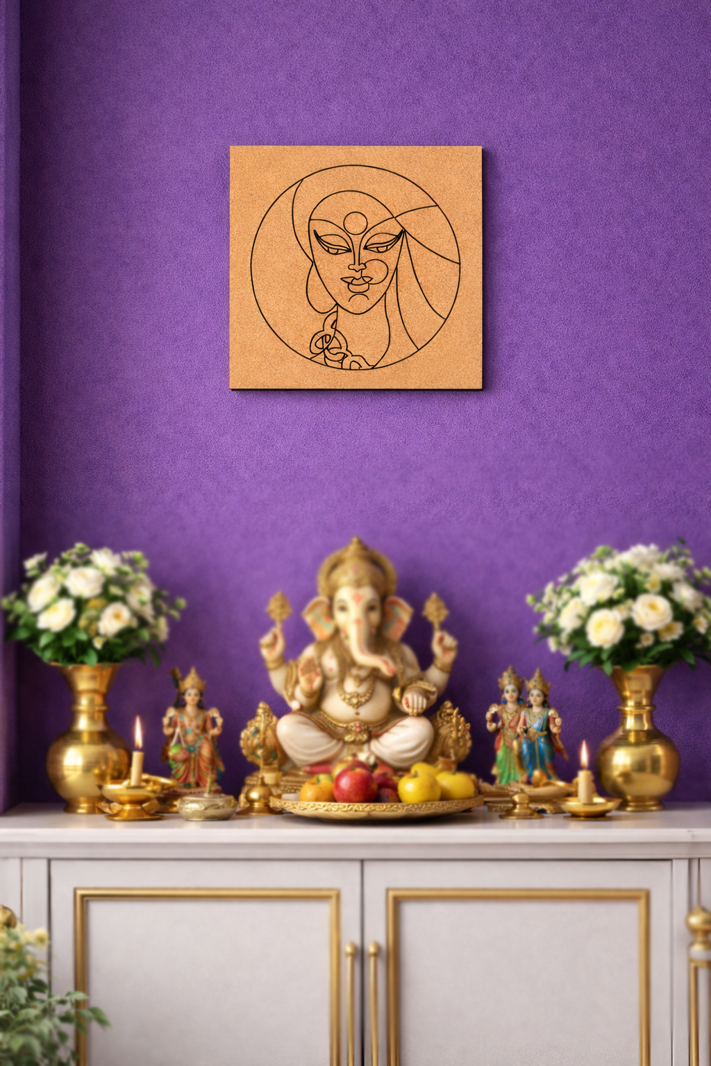 Decorative setup with a statue of Ganesha, flowers, and a MDF DIY framed artwork on a purple wall.