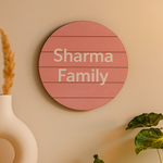 Round MDF board with 'Sharma Family' text on a beige wall.