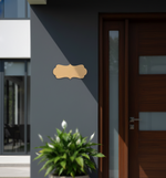 Modern house exterior with a wooden door and decorative nameplate on a gray wall.