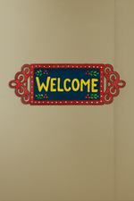 Decorative 'Welcome' sign with a red border on a beige wall.