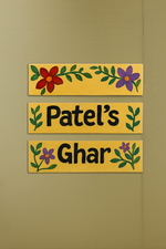 Decorative nameplate with floral designs on a yellow background, featuring 'Patel's Ghar' text.