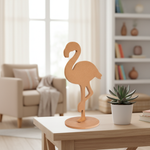 Unpainted MDF flamingo décor standing on light wooden table with indoor plant