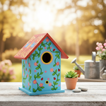 Brightly painted MDF birdhouse with red roof and floral designs in garden setting