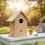 Minimal MDF birdhouse displayed on white table, sunny backyard background