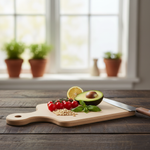 Fresh avocado half, cherry tomatoes, lemon slice, basil leaves, pine nuts, and knife on wooden cutting board