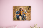 Decorative photo frame with a family picture on a pink wall.
