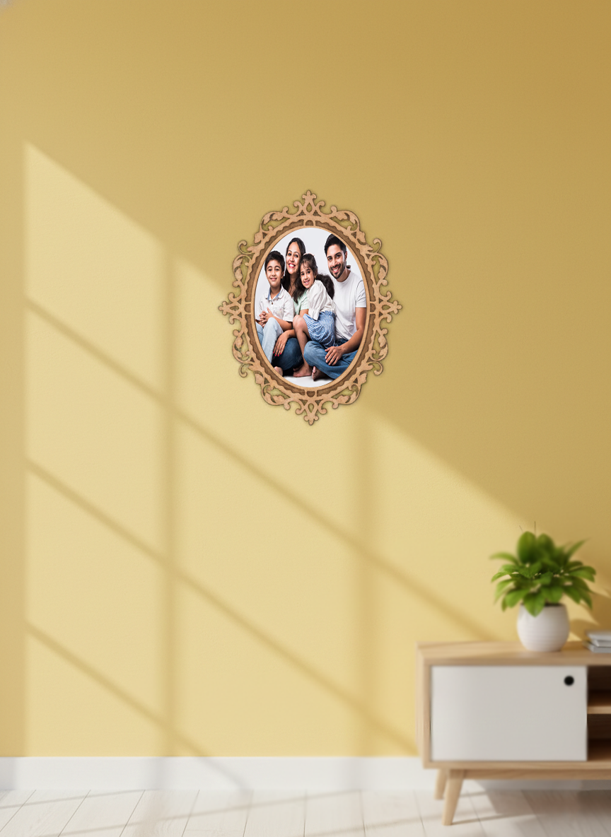 Decorative oval photo frame with a family photo on a yellow wall with a plant and cabinet below.