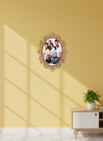 Decorative oval photo frame with a family photo on a yellow wall with a plant and cabinet below.