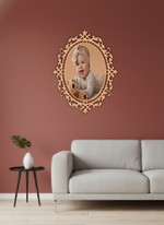 Decorative photo frame with a child's photo on a pink wall above a gray sofa.