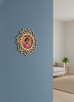 Decorative photo frame with a photo of a child on a blue wall in a room with a couch and plant.