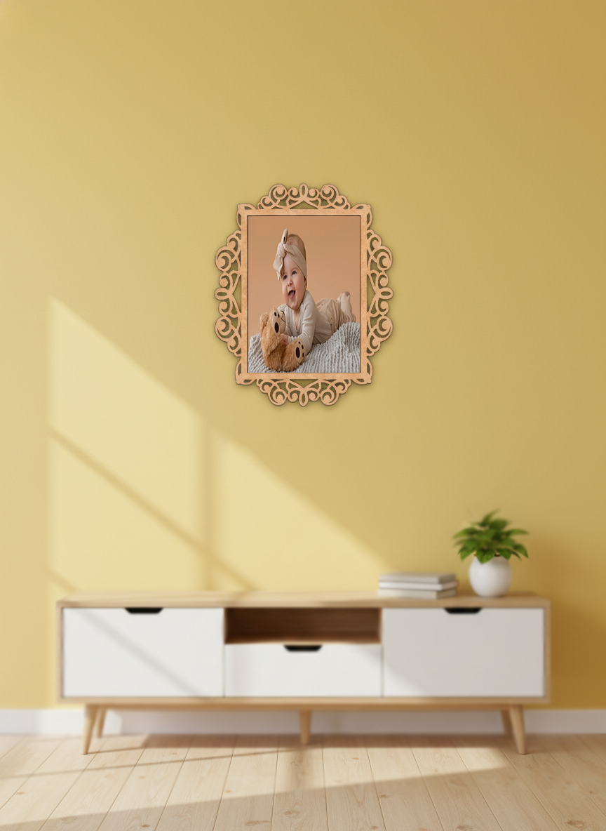 Decorative photo frame with a photo of a baby and teddy bear on a yellow wall above a white cabinet.
