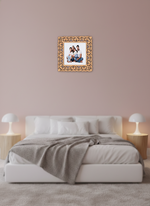 Decorative photo frame with a family picture on a wall above a bed in a bedroom.