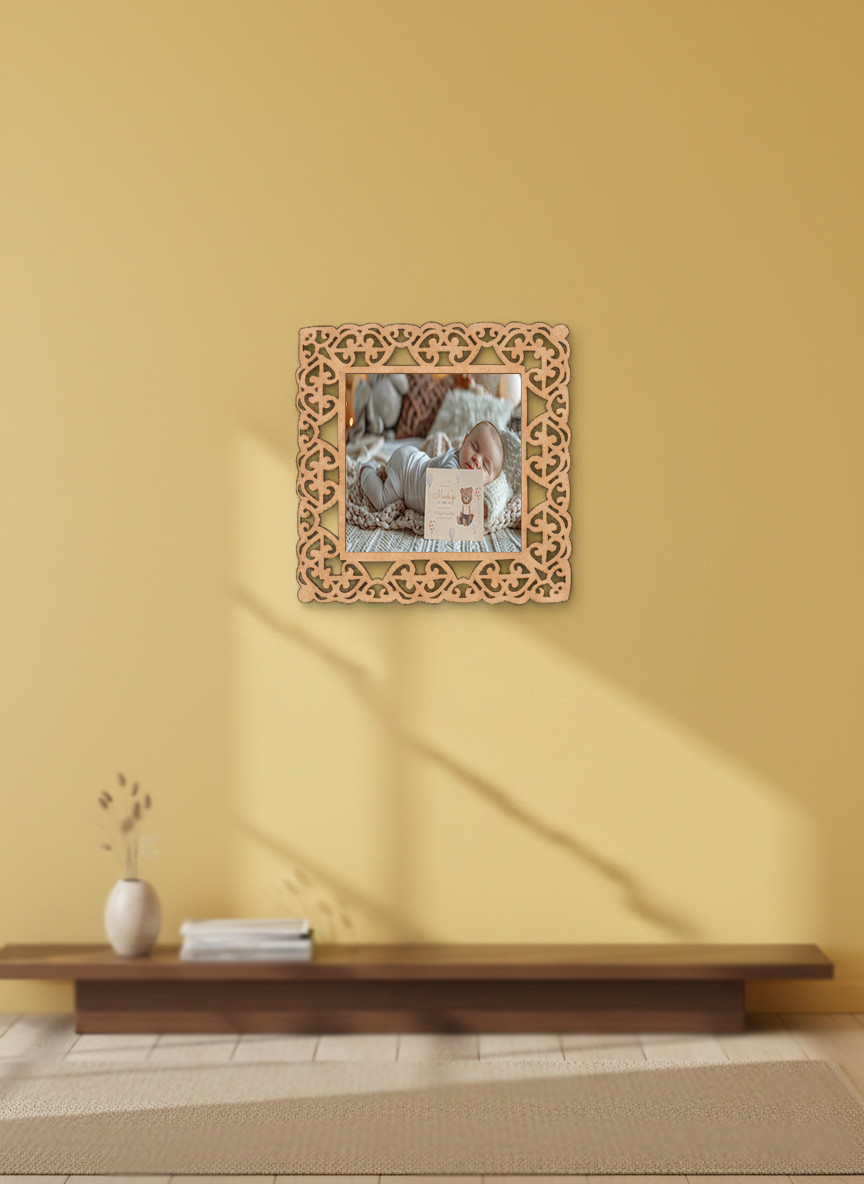 Decorative mirror with floral frame on a yellow wall above a wooden bench.