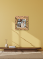 Decorative mirror with floral frame on a yellow wall above a wooden bench.