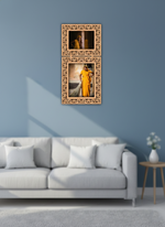 Decorative photo frame with two photos of a woman in a yellow saree on a blue wall above a white sofa.