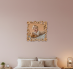 Decorative photo frame with a baby photo on a pink wall above a bed.