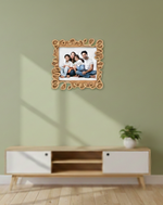 Decorative photo frame with a family picture on a wall above a wooden cabinet.