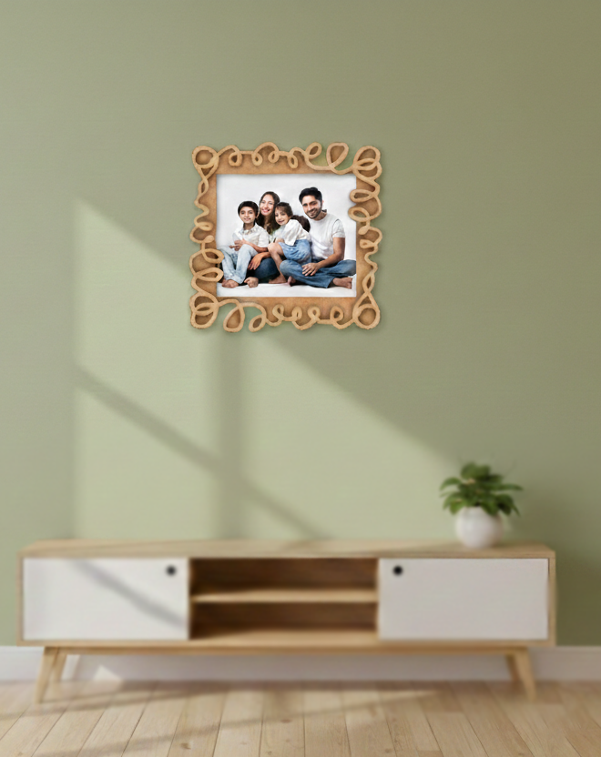 Decorative photo frame with a family picture on a wall above a wooden cabinet.