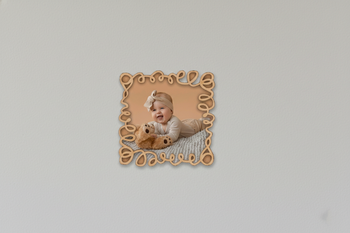 Framed photo of a baby with a teddy bear on a light gray background