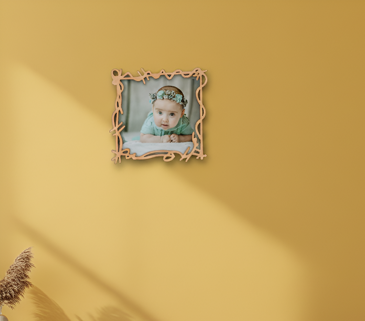 Decorative photo frame with a baby picture on a yellow wall