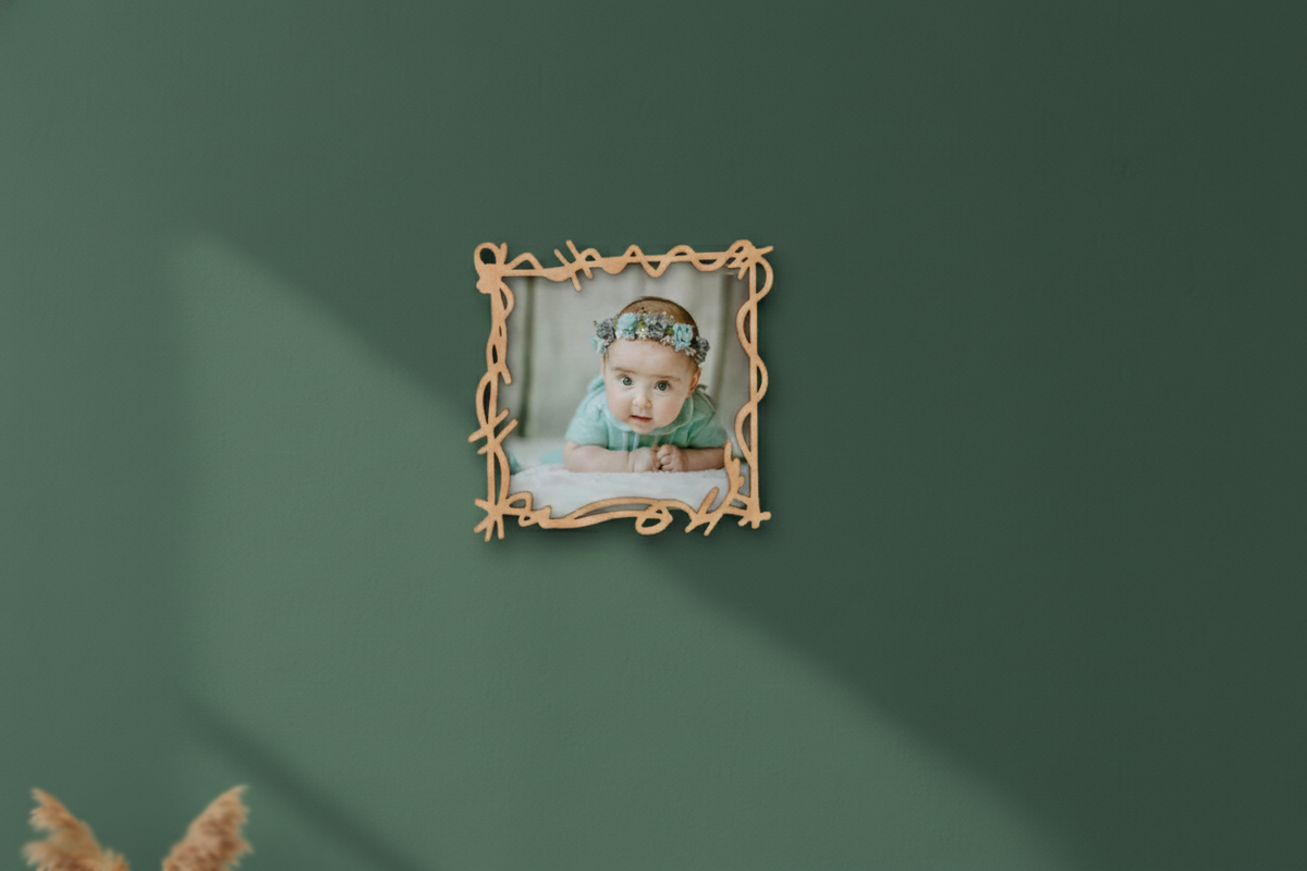 Small framed picture of a baby on a green wall