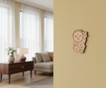 MDF DIY wall art decoration of a baby Buddha on a beige wall in a living room.