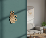 MDF DIY wall art decorative item on a teal wall with a living room in the background