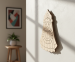  MDF DIY wall art of a face on a white wall with a plant and stool in the background