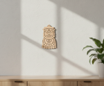  MDF DIY  wall art with a face design on a white wall with a plant in the corner