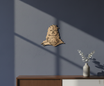 MDF DIY wall art of a face on a blue wall with a vase on a table below.