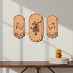 Three decorative  MDF DIY wall art with engraved designs on a white wall above a wooden table.