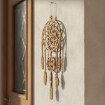 MDF dreamcatcher hanging on a textured wall next to a door.