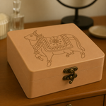 BeigeMDF Lock box with a pichwai cow design on a wooden surface