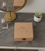 MDF box with engraved design on a marble surface with a small plant and mirror in the background.
