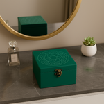 Handpainted MDF Green jewelry box with floral design on a marble surface, mirror, and plant in the background