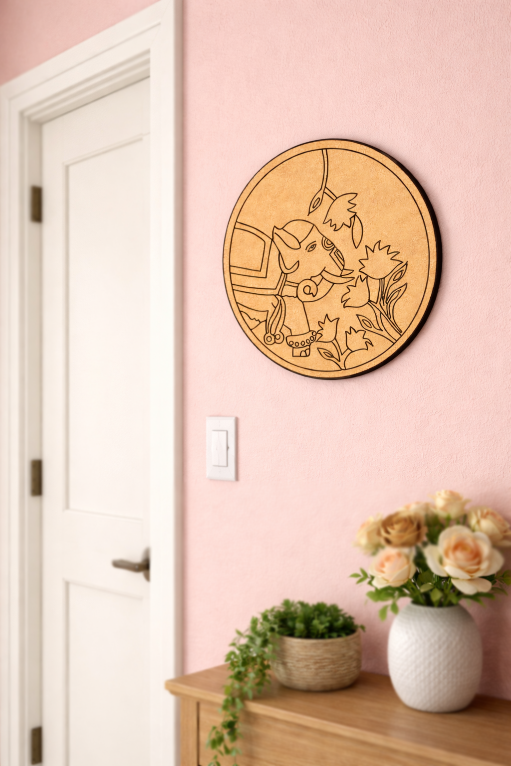 MDF DIY wall art of a elephant on a pink wall above a wooden cabinet with plants and flowers.