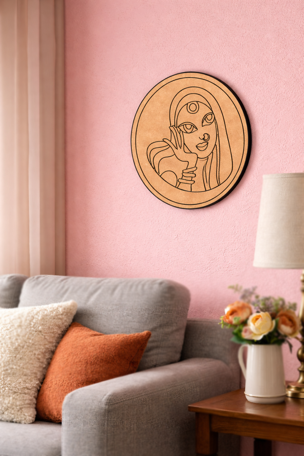 MDF DIY  wall art of a stylized face on a pink wall above a gray sofa.
