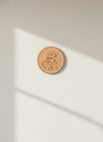 Circular MDF DIY wall art with a design on a light beige surface