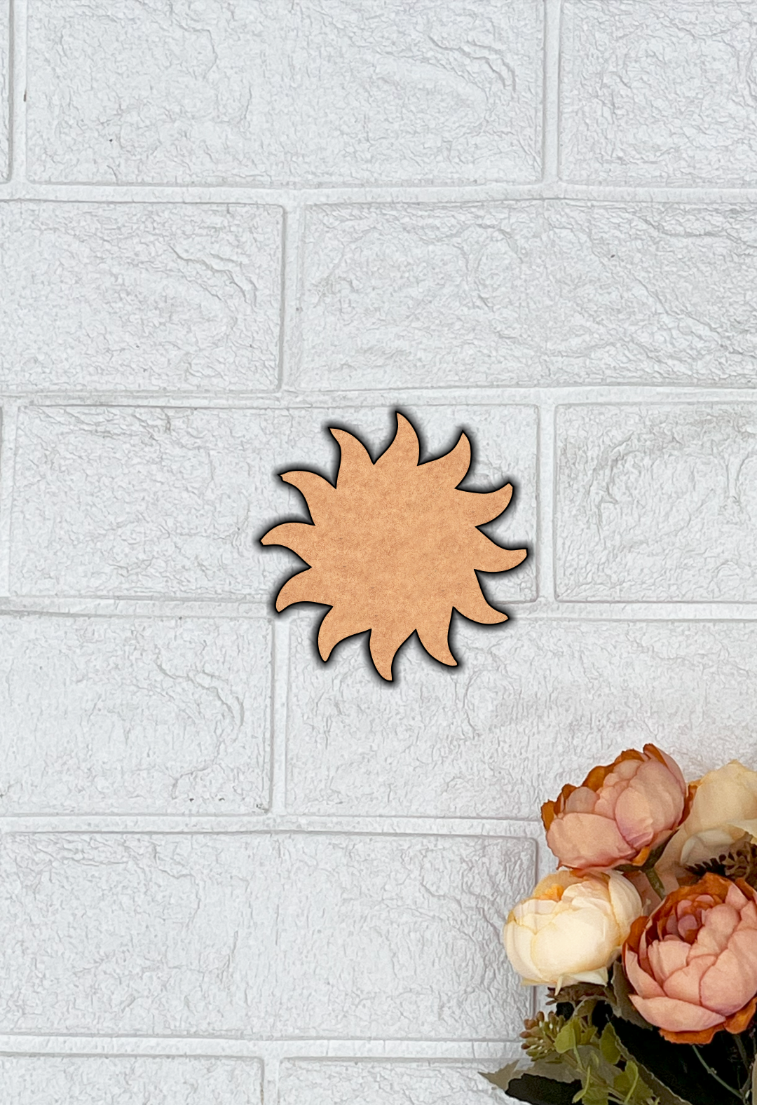 Unfinished MDF sun shape cutout with curved rays on a grey background