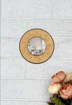 Round decorative DIY wall mirror with floral patterns on a textured white wall.