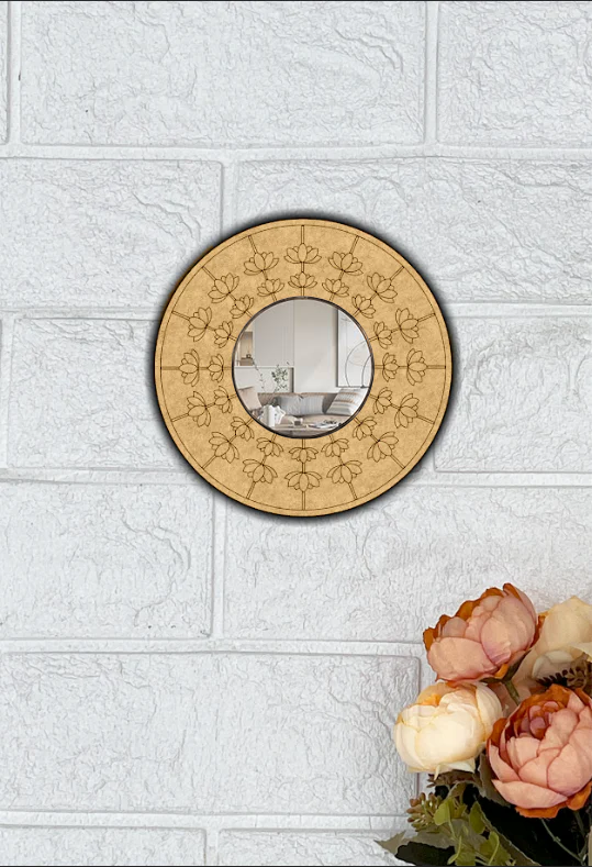 Round decorative DIY wall mirror with floral patterns on a textured white wall.