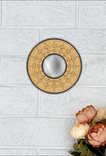 Round MDF wall mirror with floral engraved frame on white textured wall