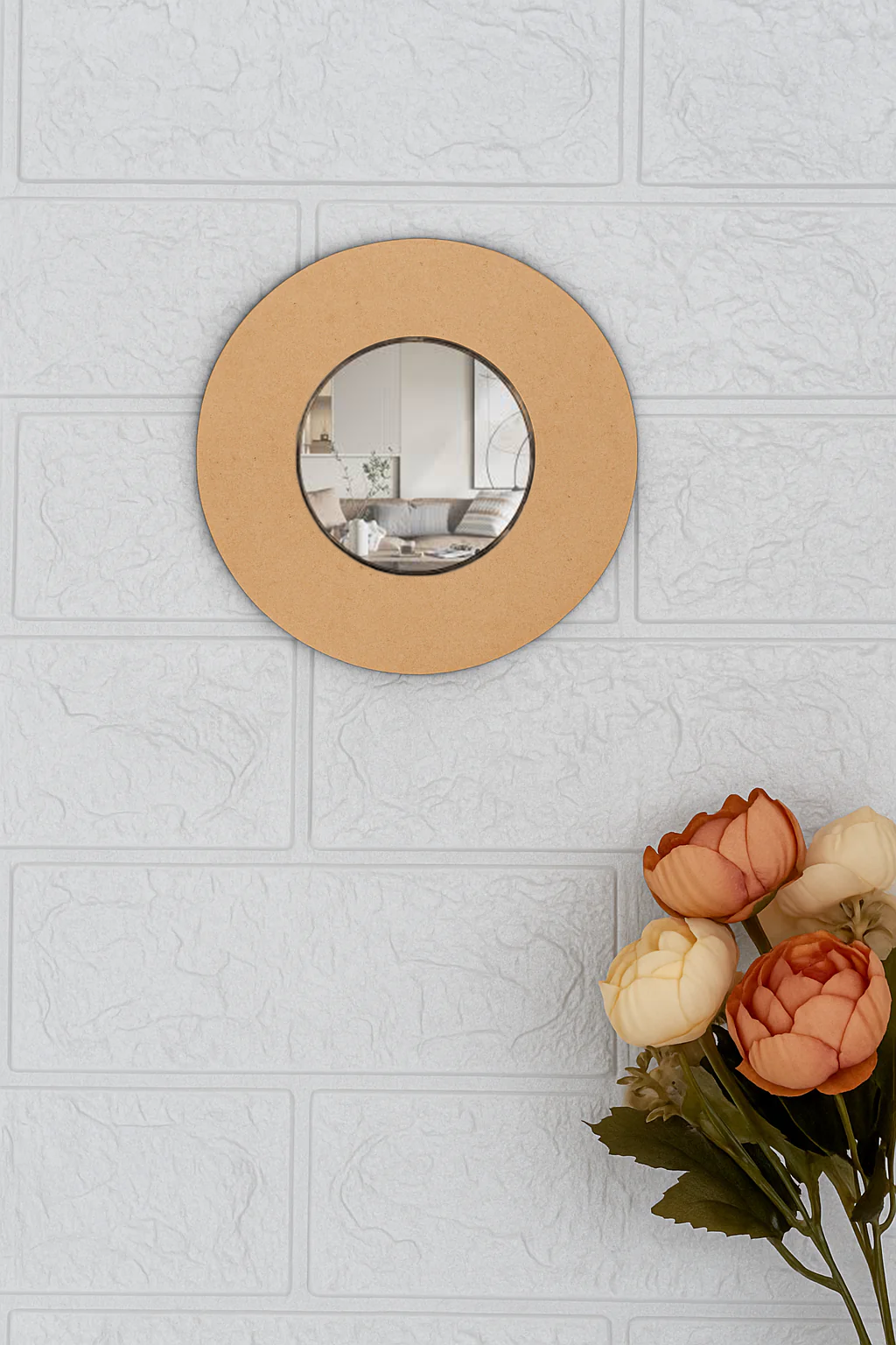 Round DIY wall mirror on a light gray tiled wall with flowers in the foreground.