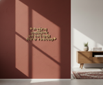 MDF Shloka wall art featuring the Bhagavad Gita verses, mounted on a terracotta-colored wall in a modern room setting with warm sunlight and shadows.