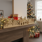 DIY Christmas village MDF décor with LED lights displayed on table in holiday living room setting 