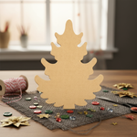 DIY MDF Christmas tree cutout for painting and holiday decor standing on decorated table 