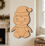 MDF DIY penguin decoration on a wall with festive decorations in the background