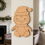 MDF DIY penguin decoration with a Santa hat on a wall in a cozy living room.