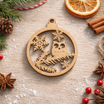 Round DIY MDF Christmas ornament cutout with owl, pine branches and snowflakes, laser-cut hanging decor shape on decorative table 