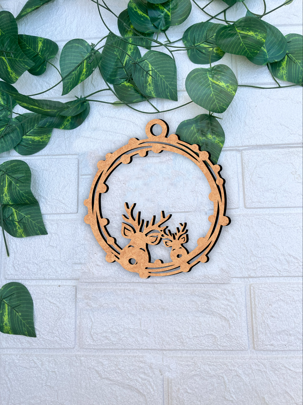 Laser-cut DIY MDF reindeer frame ornament cutout with hanging loop, Christmas decoration mount on white wall